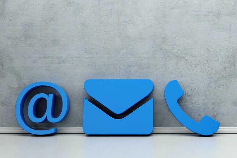 Blaue Kontakt Icons (Mail, Post, Telefon) an eine Wand gelehnt