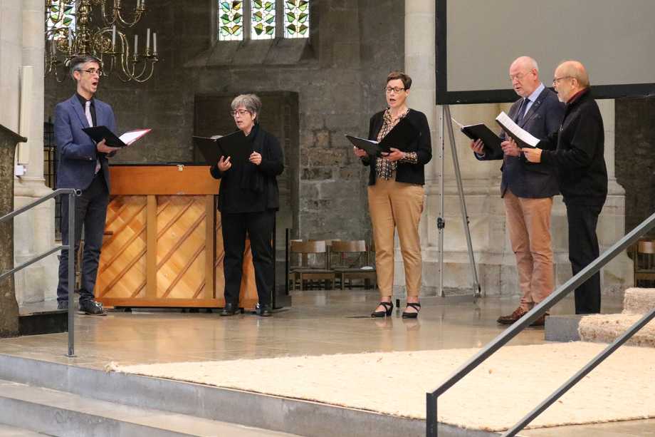 Fünf Personen singen in einer Kirche.