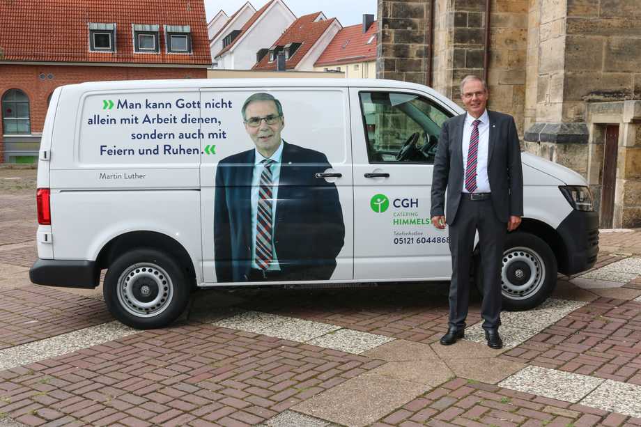 Ein Mann vor einem Lieferwagen. Darauf das Foto des gleichen Mannes und ein Zitat von Martin Luther: "Mann kann Gott nicht allein mit Arbeit dienen, sondern auch mit Feiern und Ruhen."