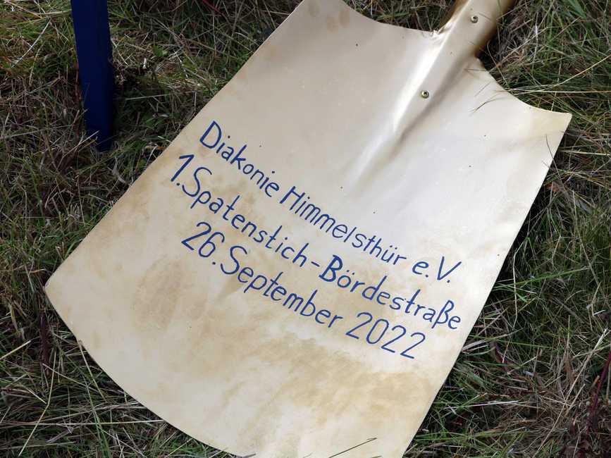 Schaufelblatt eines Spatens mit der Aufschrift "Diakonie Himmelsthür - 1. Spatenstich-Bördestraße - 26. September 2022"