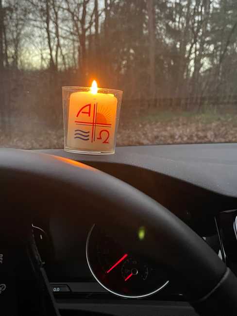 Eine brennende Kerze steht auf dem Armaturenbrett eines haltenden Fahrzeugs